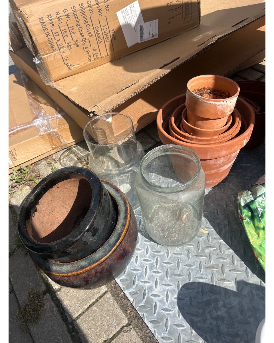 kleine en grote bloempotten: wit, terracotta en zwart.