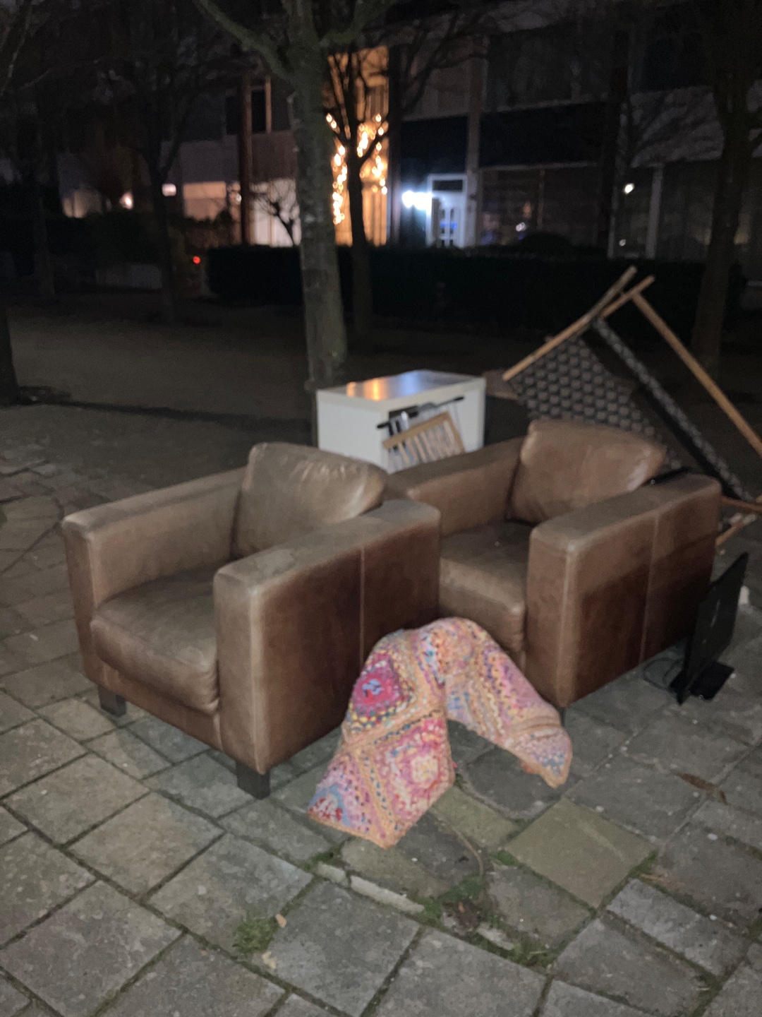 Two leather chairs, colorful carpet, wooden bench, small white cabinet, dish drying rack, scren