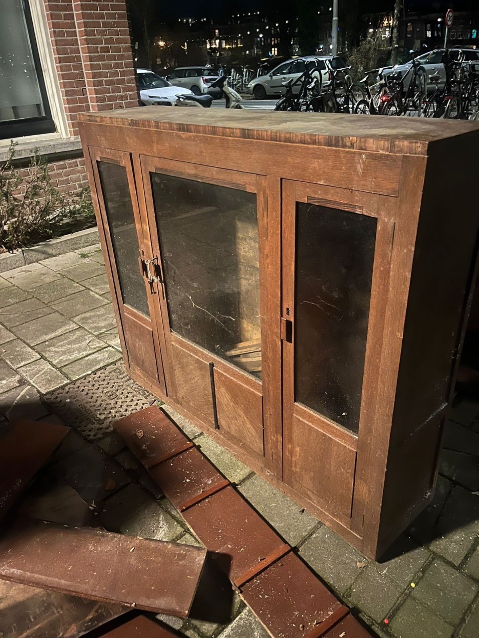 Houten vitrinekast, glas is intact. Planken liggen erbij