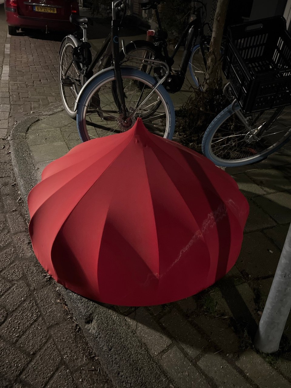Enormous red lampshade from red fabric, inside had silver lining.  Grensstraat 31, oost