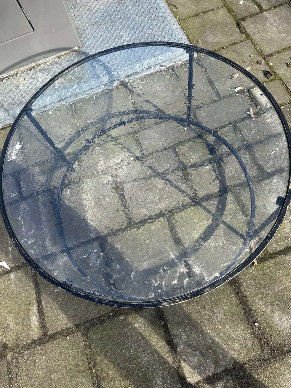 Glazen salontafel, metaal lijkt esthetisch wat slijtage te vertonen.