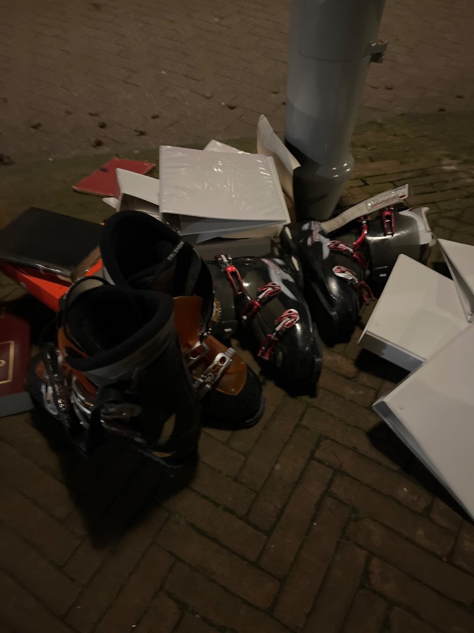 2 pairs ski boots, 1 pair is solomon, surrounded by white binders