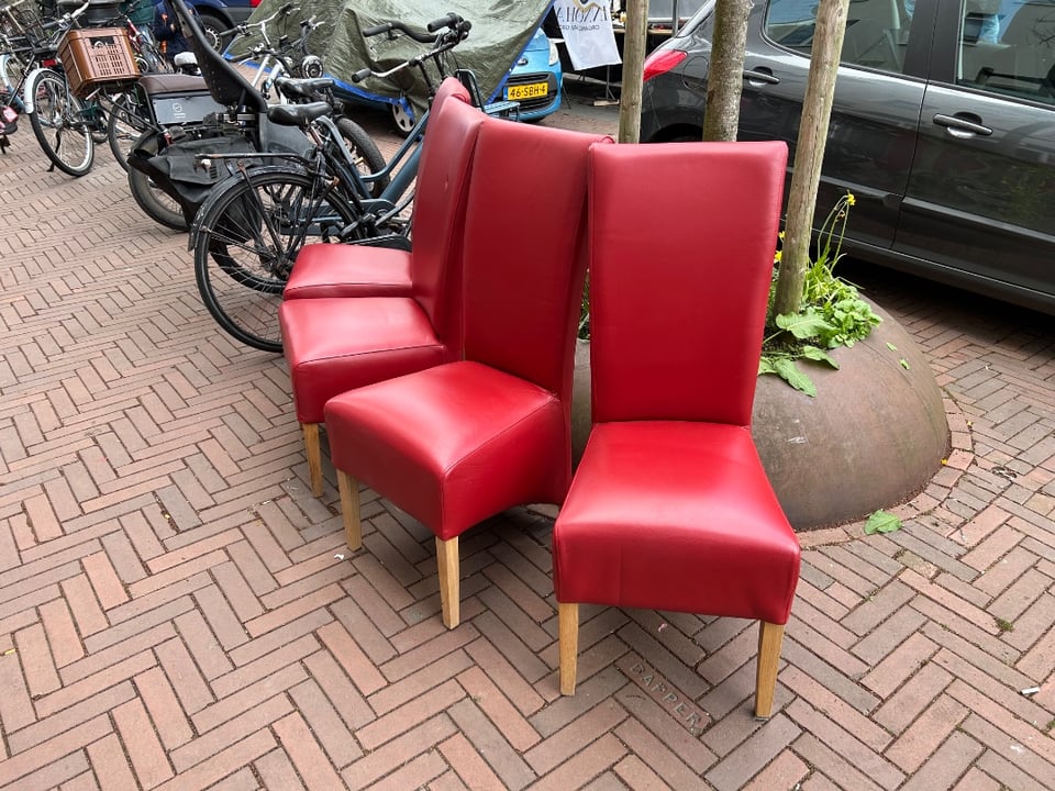 Vier stoelen op een rij aan de deur bij het Afvalpaleis