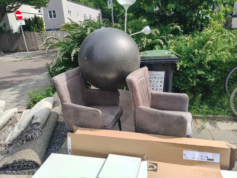 Kleden en stoelen in goede staat in Betondorp bij de container in de Akkerstraat