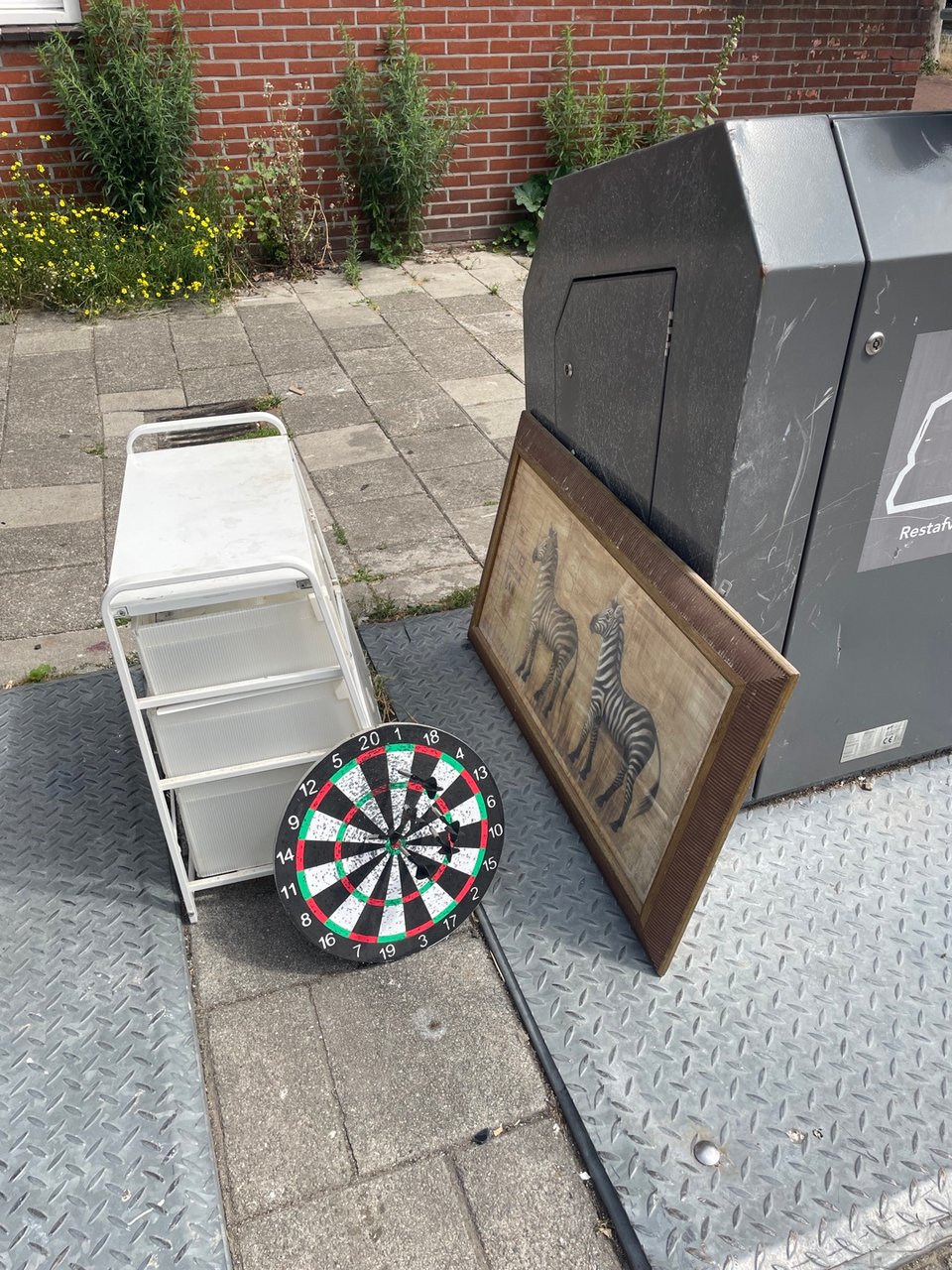 Dart board, ladekastje en schilderij/prent