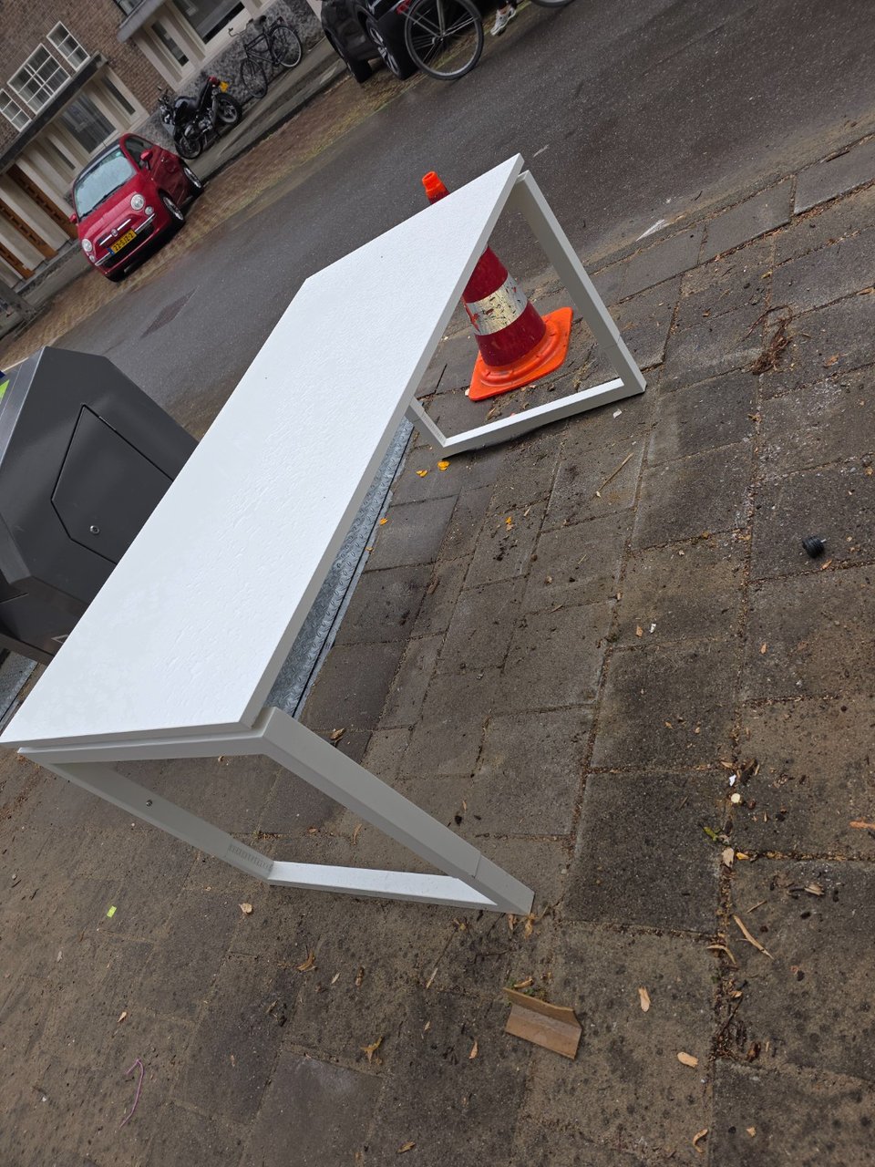 White metal desk and traffic cone