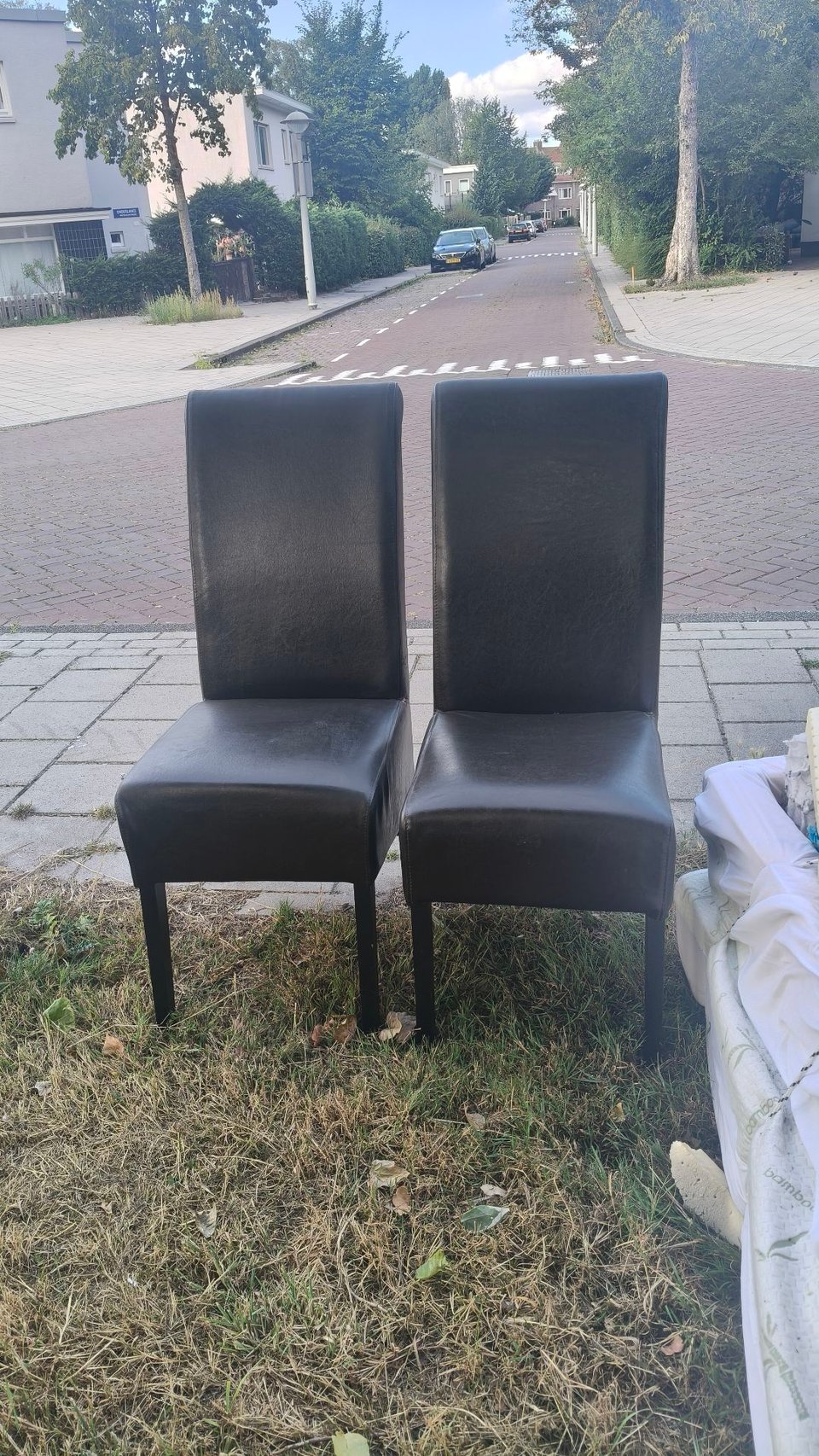 Drie stoelen bij de afvalcontainer tegenover Onderlangs 65