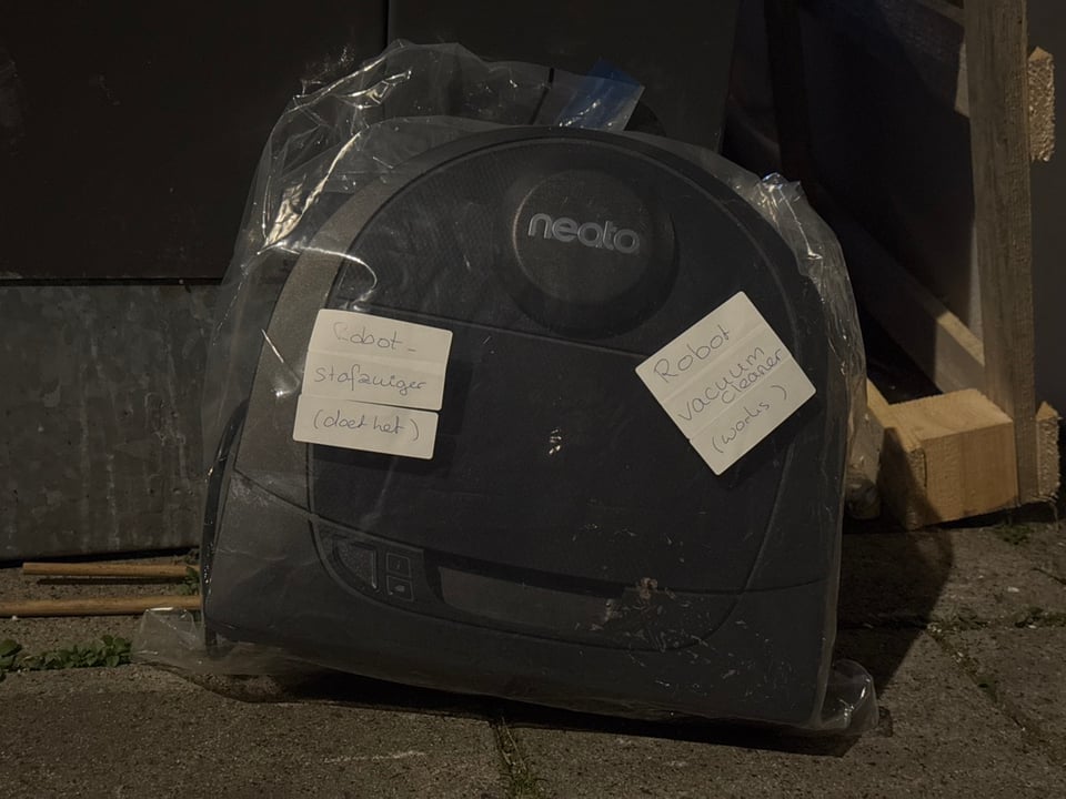 Robot vacuum cleaner!
(Leaning against the glass container, on the street-side.)